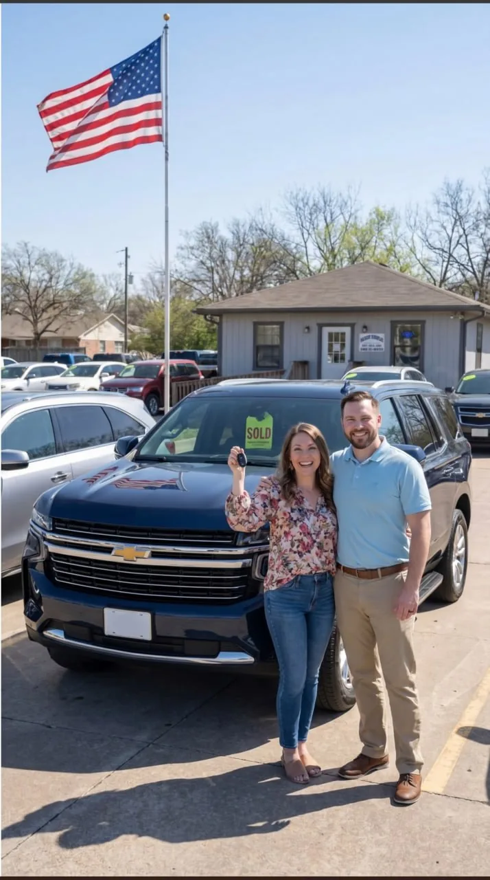 A couple standing beside their truck at the dealership