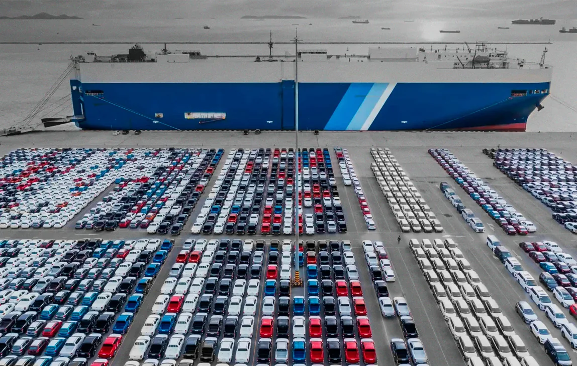 Thousands of cars lined up at a shipping port, seen from above